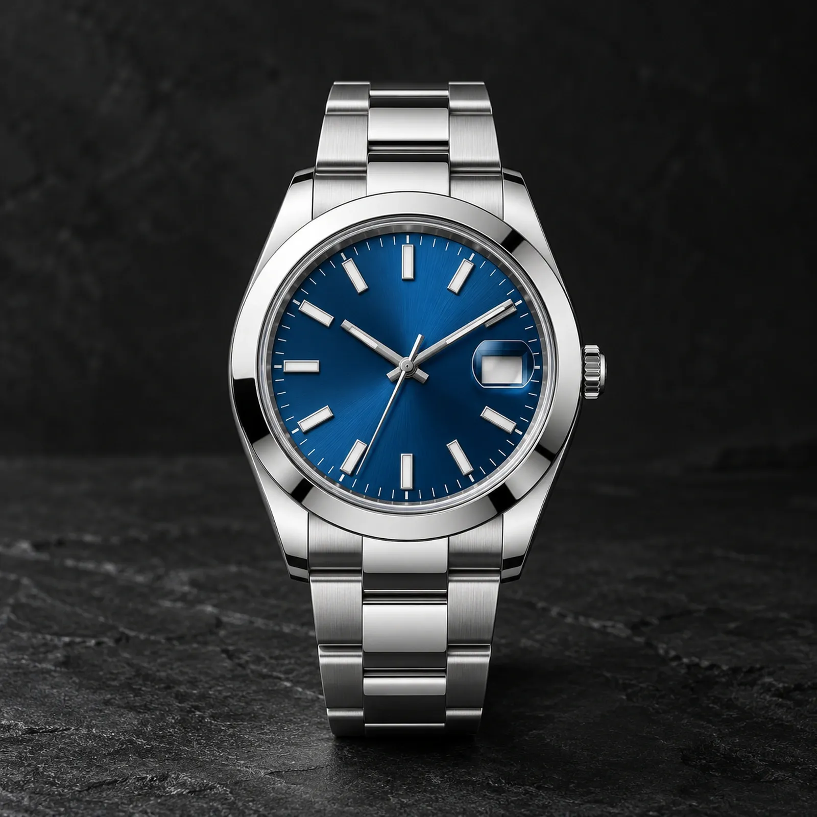 Front view of a stainless steel watch with bright blue dial, smooth bezel and steel bracelet on a dark stone background.